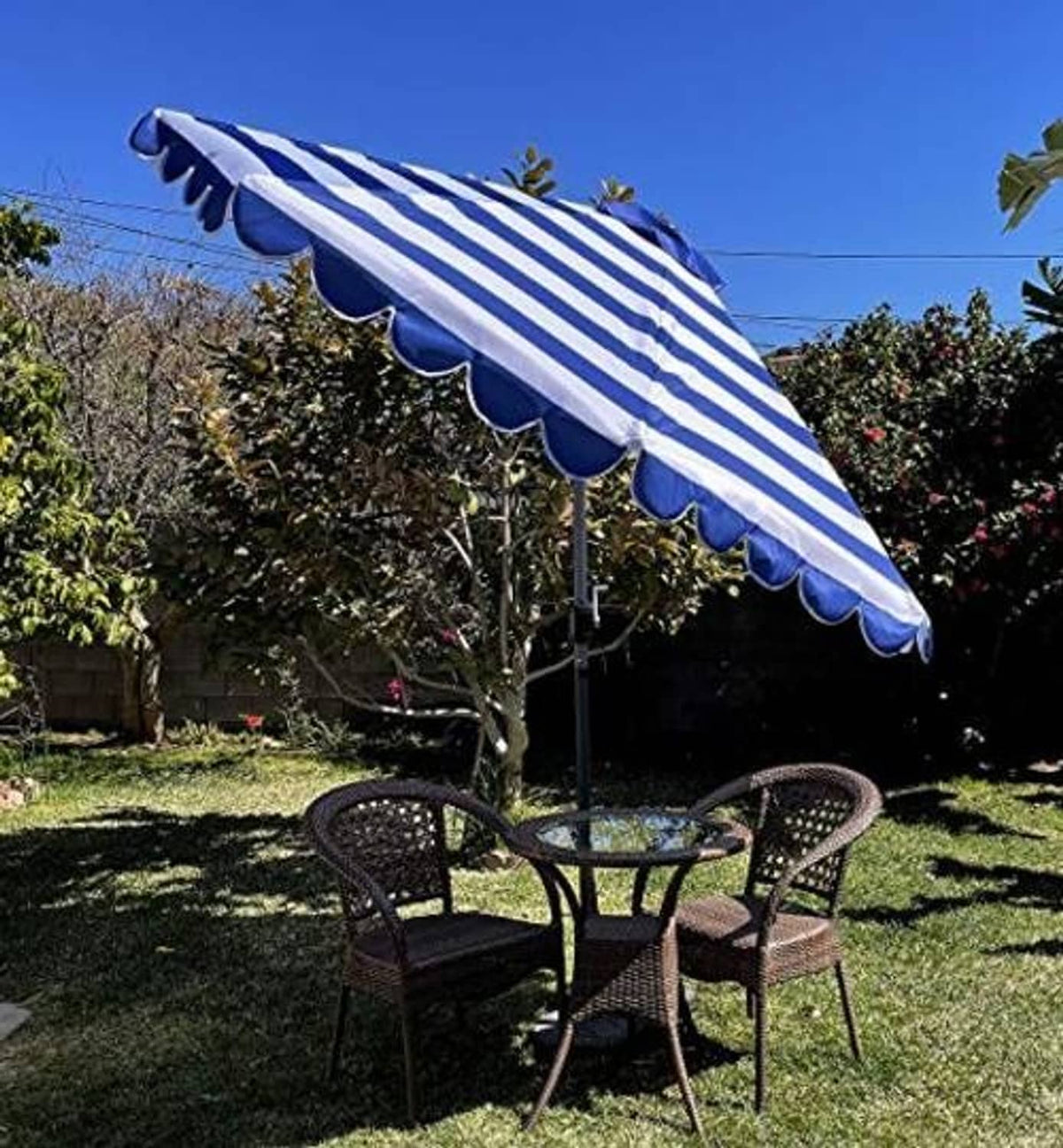 Side view of royal and white striped umbrella canopy replacement with scalloped valance edge