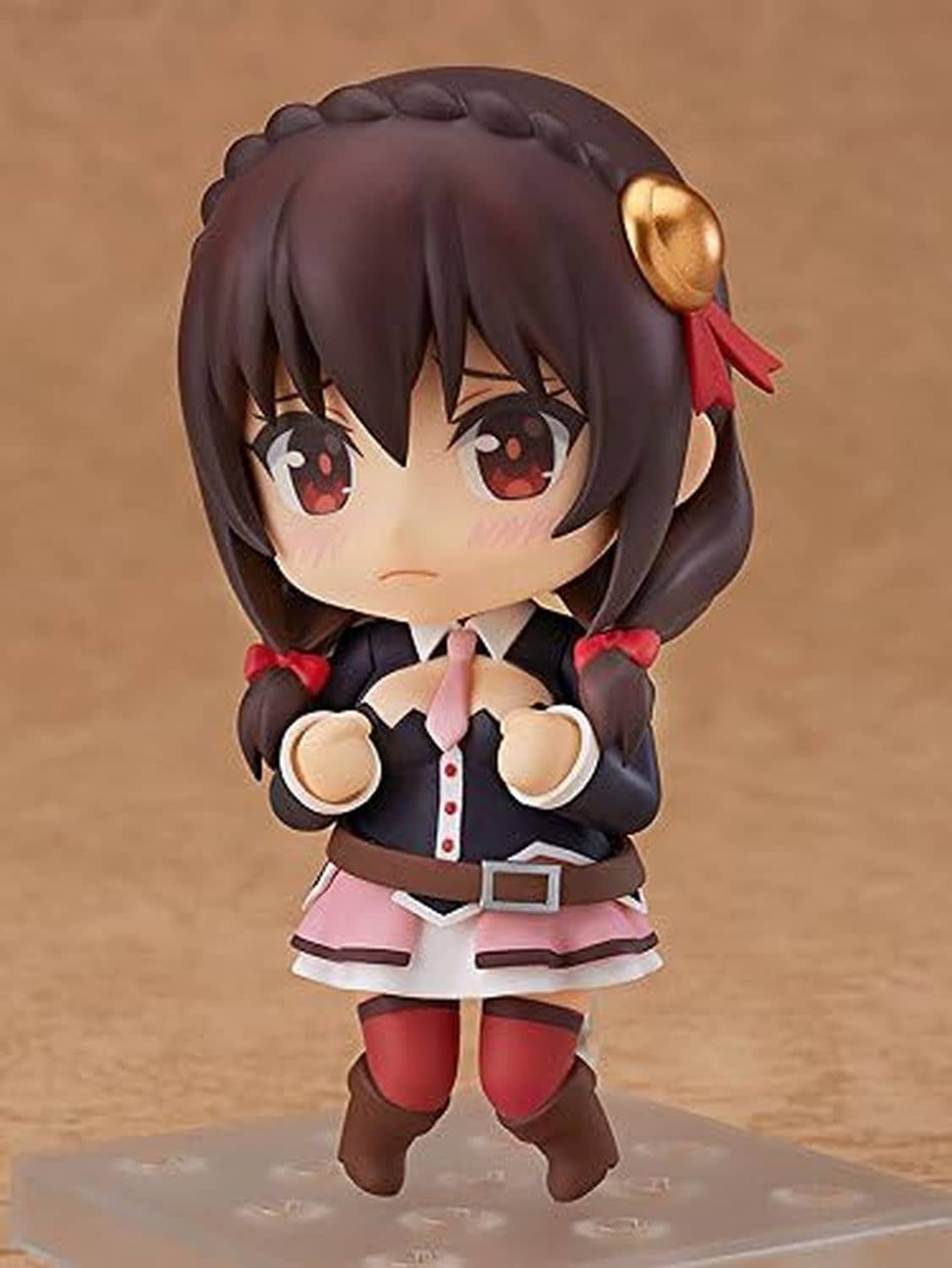 Chibi Nendoroid figure with dark hair, red eyes, pink skirt, fists raised, gold-horn hair accessory.