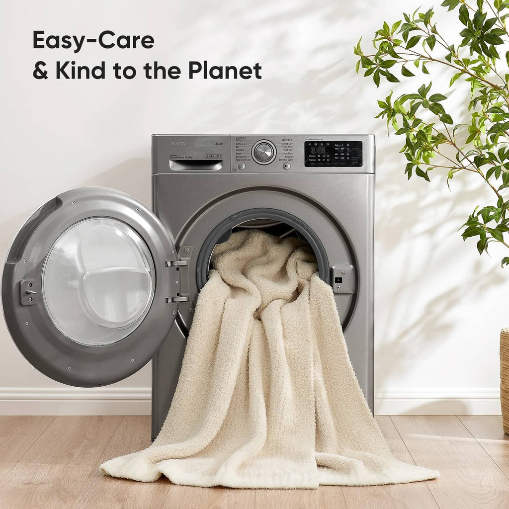 Ivory plush throw blanket partially over open dryer, fluffy textured fabric