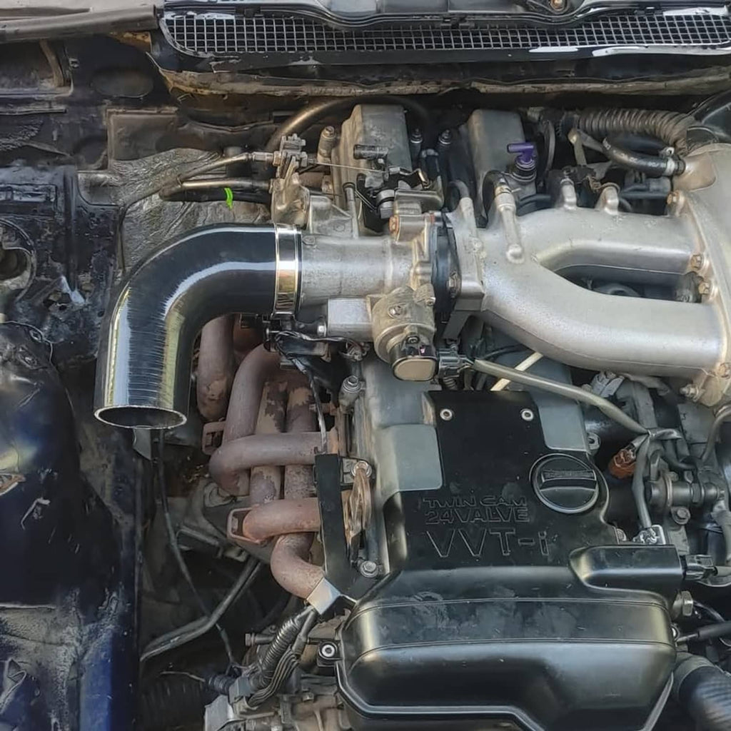 Installed black 90-degree silicone hose elbow with metal clamp on engine bay