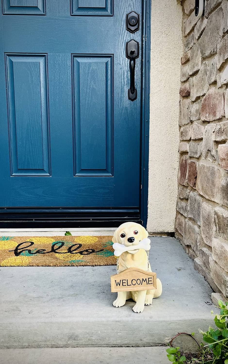Small tan Labrador puppy statue with white bone and “WELCOME” wooden sign