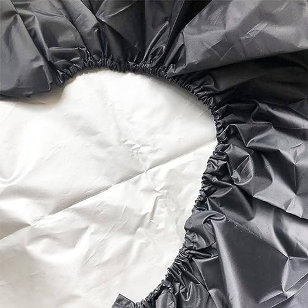 Black tire cover close-up with elastic rim edging and crinkled fabric