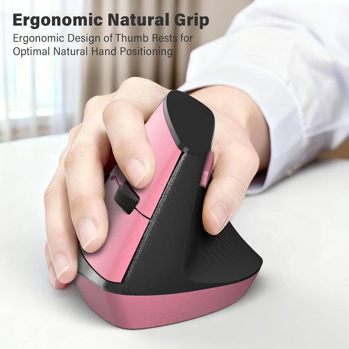 Pink and black ergonomic wireless mouse with thumb grip, held in hand