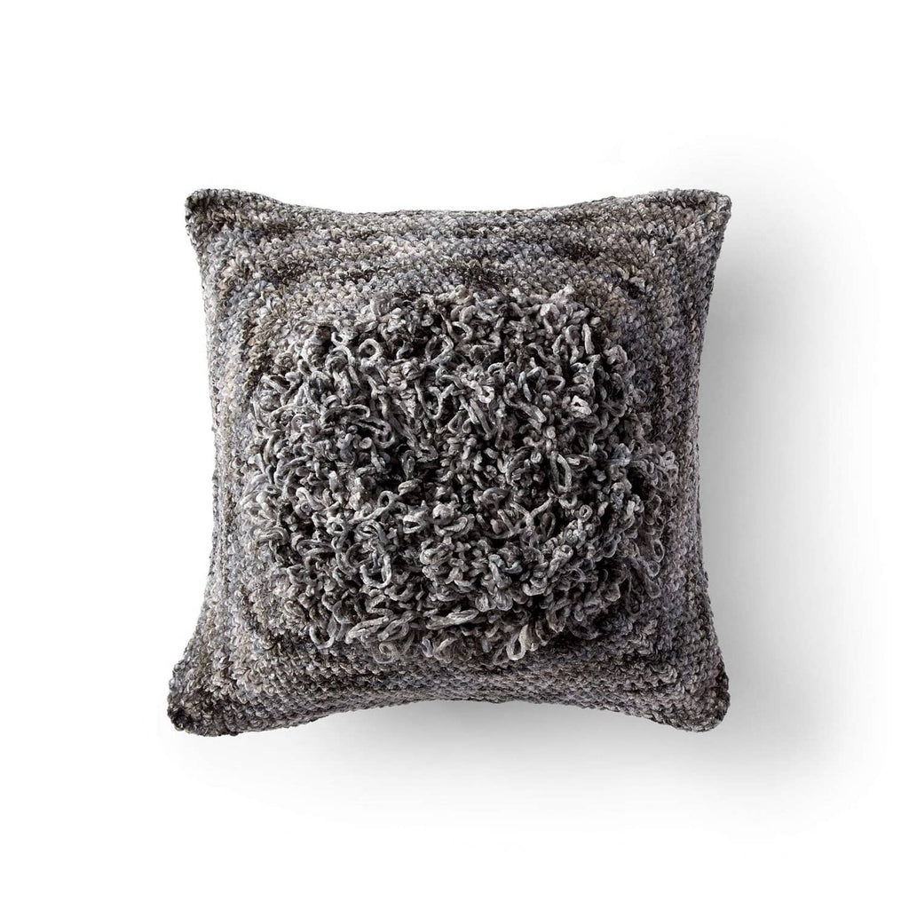 Speckled gray knit pillow with textured, fuzzy circular front