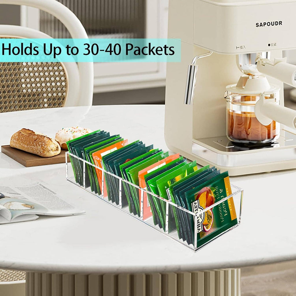Clear acrylic tea bag organizer on tabletop with tea packets in open front slots