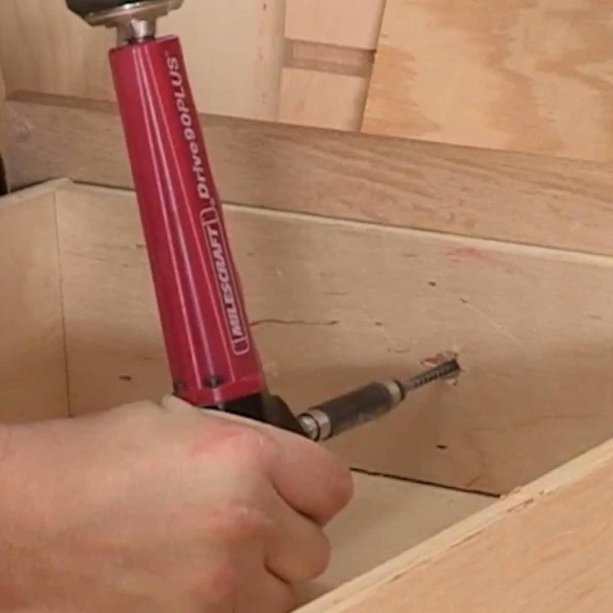 Milescraft right-angle drill attachment used to drill, red body and side-mounted bit