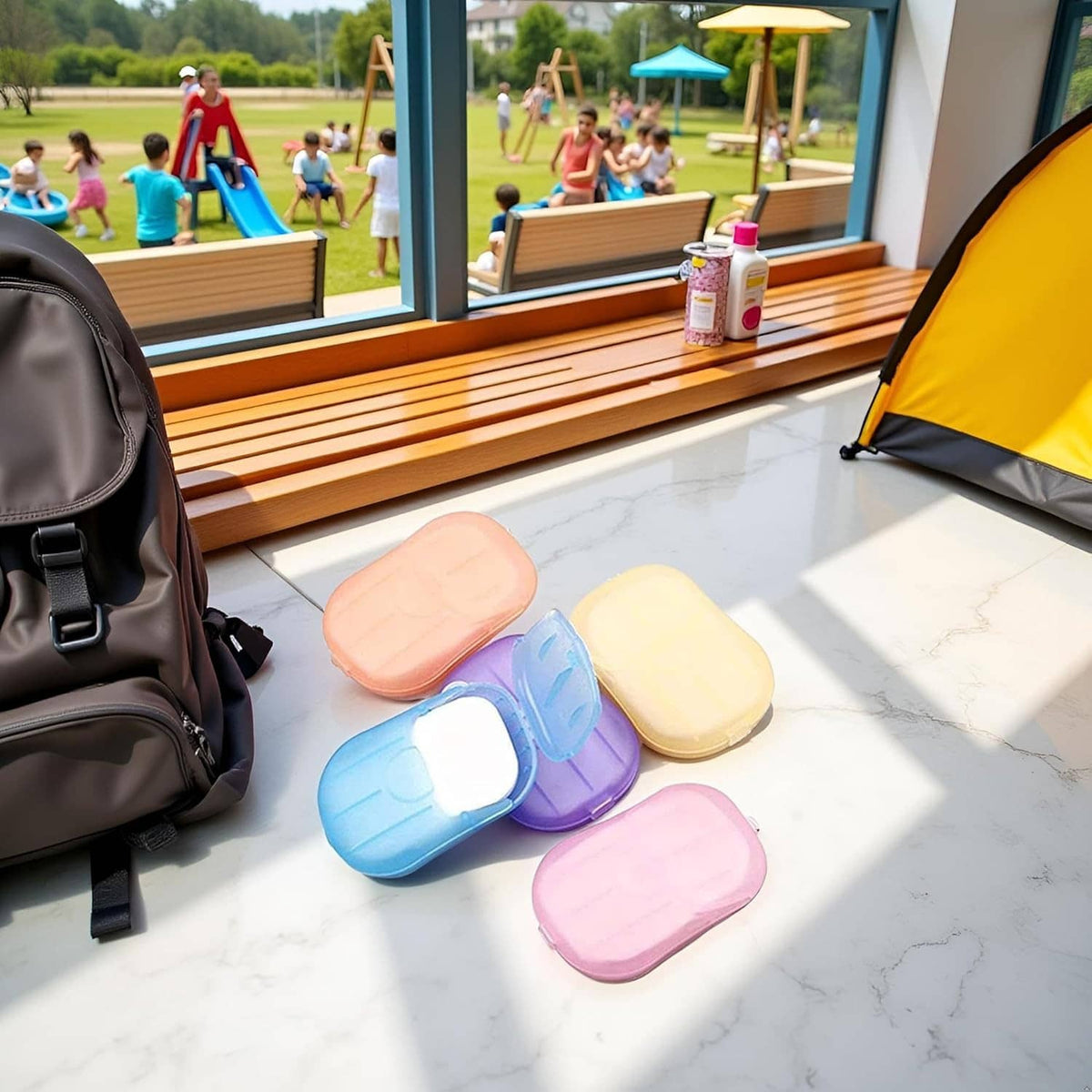 Pastel disposable soap paper bars on outdoor tiles: orange, yellow, blue, purple, pink