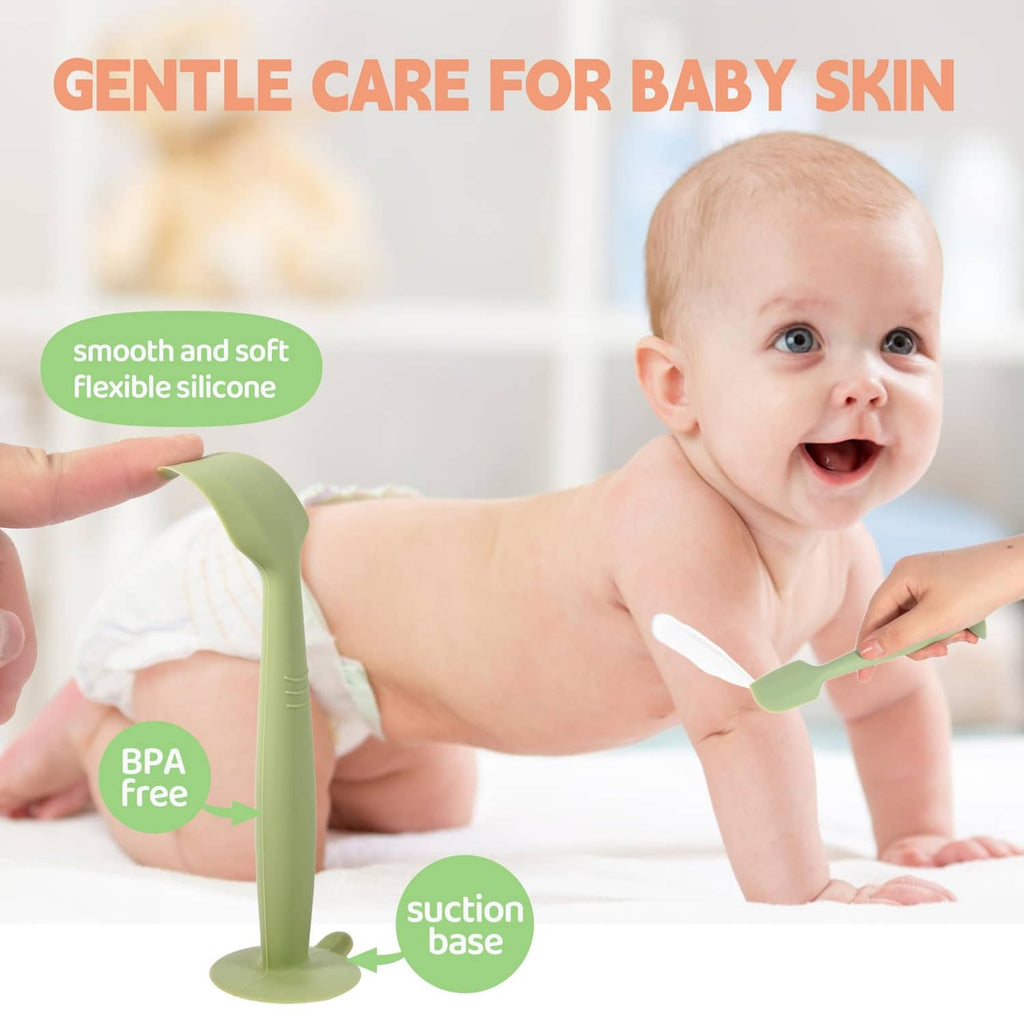Baby using a green silicone diaper spatula and a white scraper