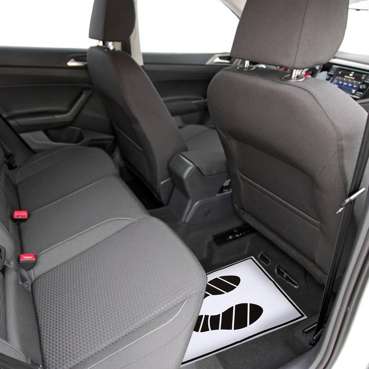 Disposable paper foot mat with black footprint print under the front passenger seat