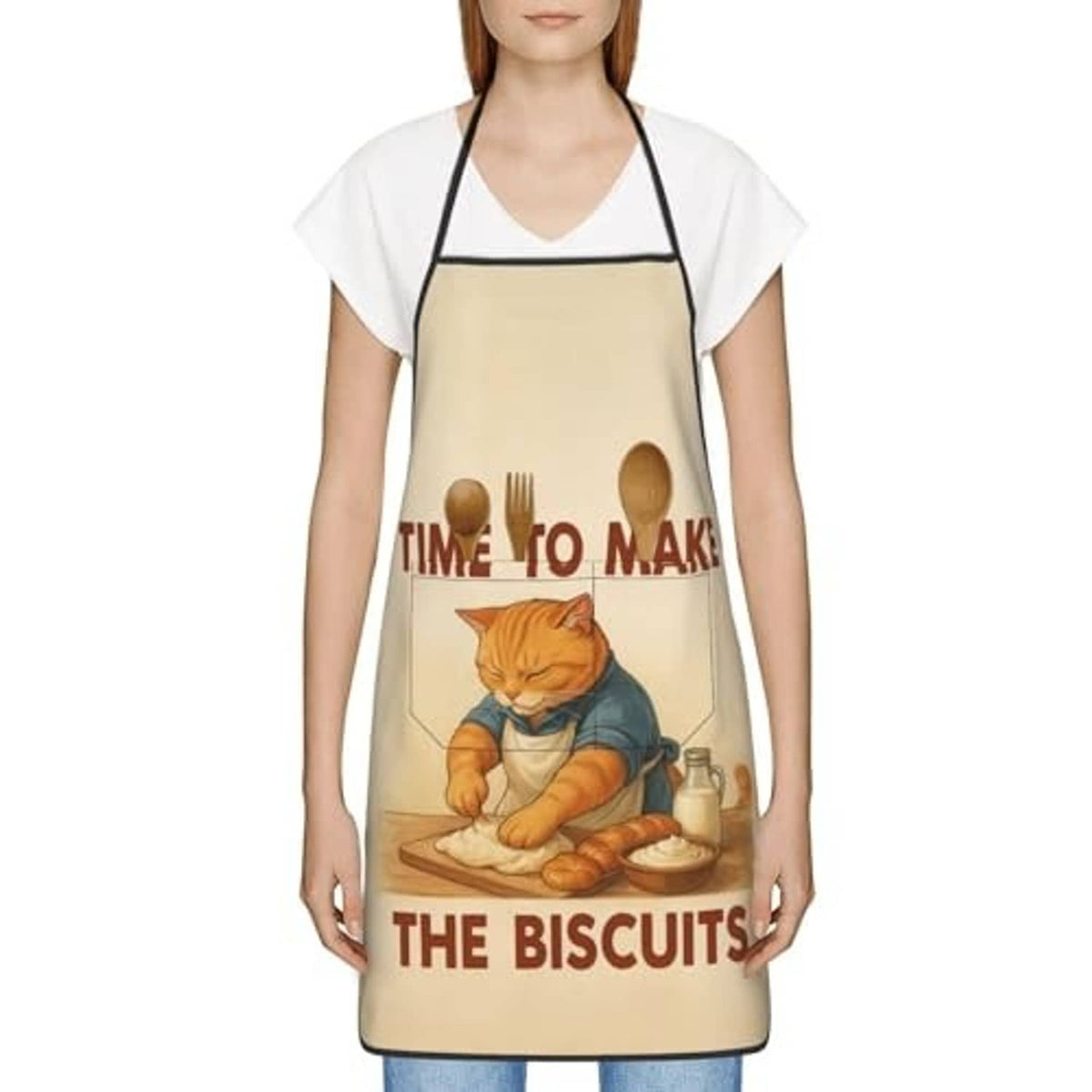Beige chef bib apron on model over short-sleeve shirt; cat and biscuits print