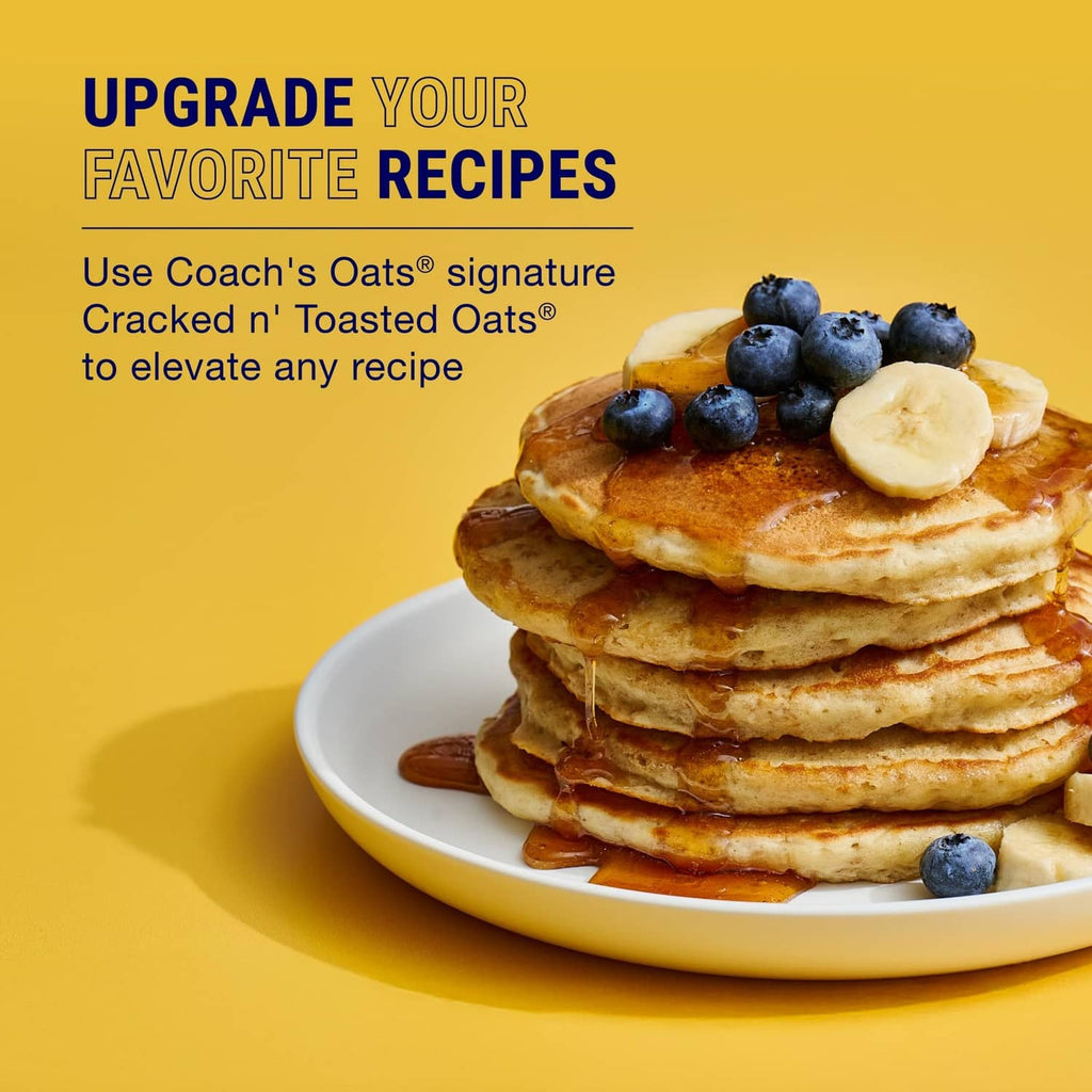 Stack of pancakes topped with banana slices and blueberries on a white plate