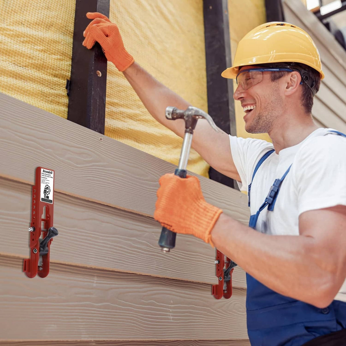 Contractor using a red siding mounting tool on wood siding with a mounted handle