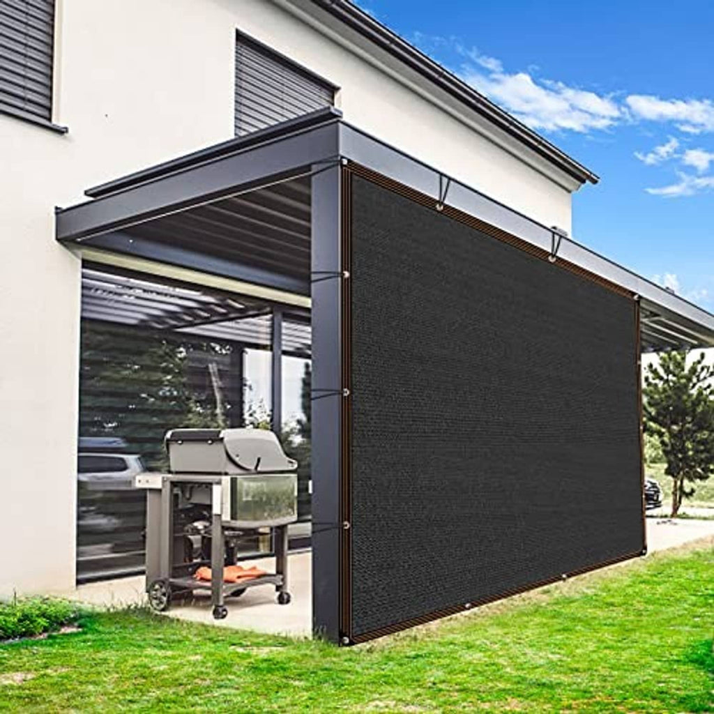 Black mesh shade cloth with brown-trim border and grommets, installed as patio side screen