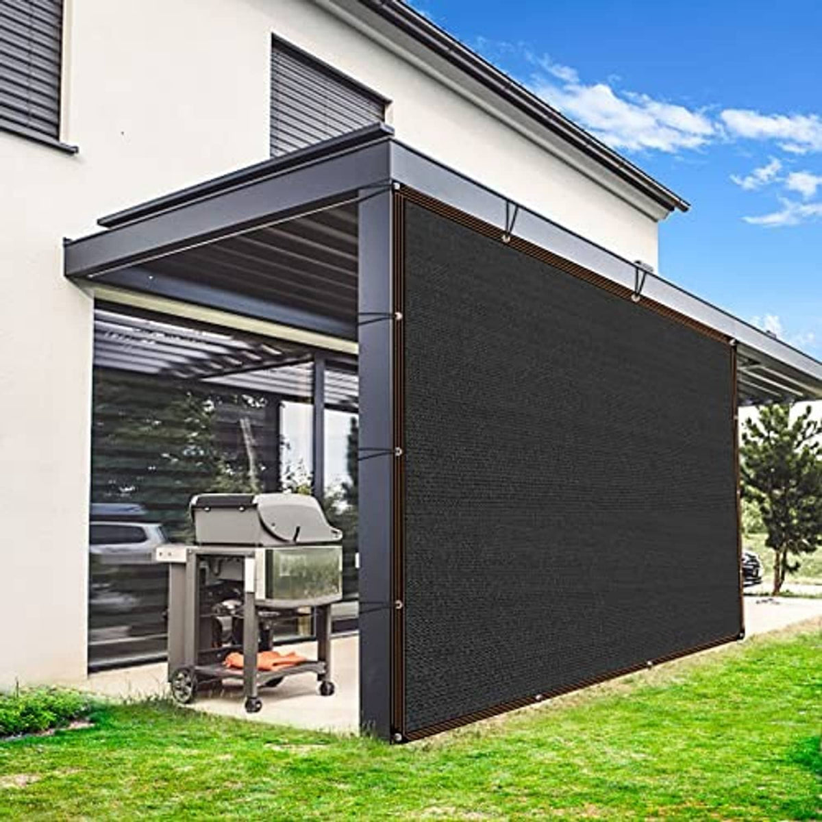Black mesh shade cloth with brown-trim border and grommets, installed as patio side screen