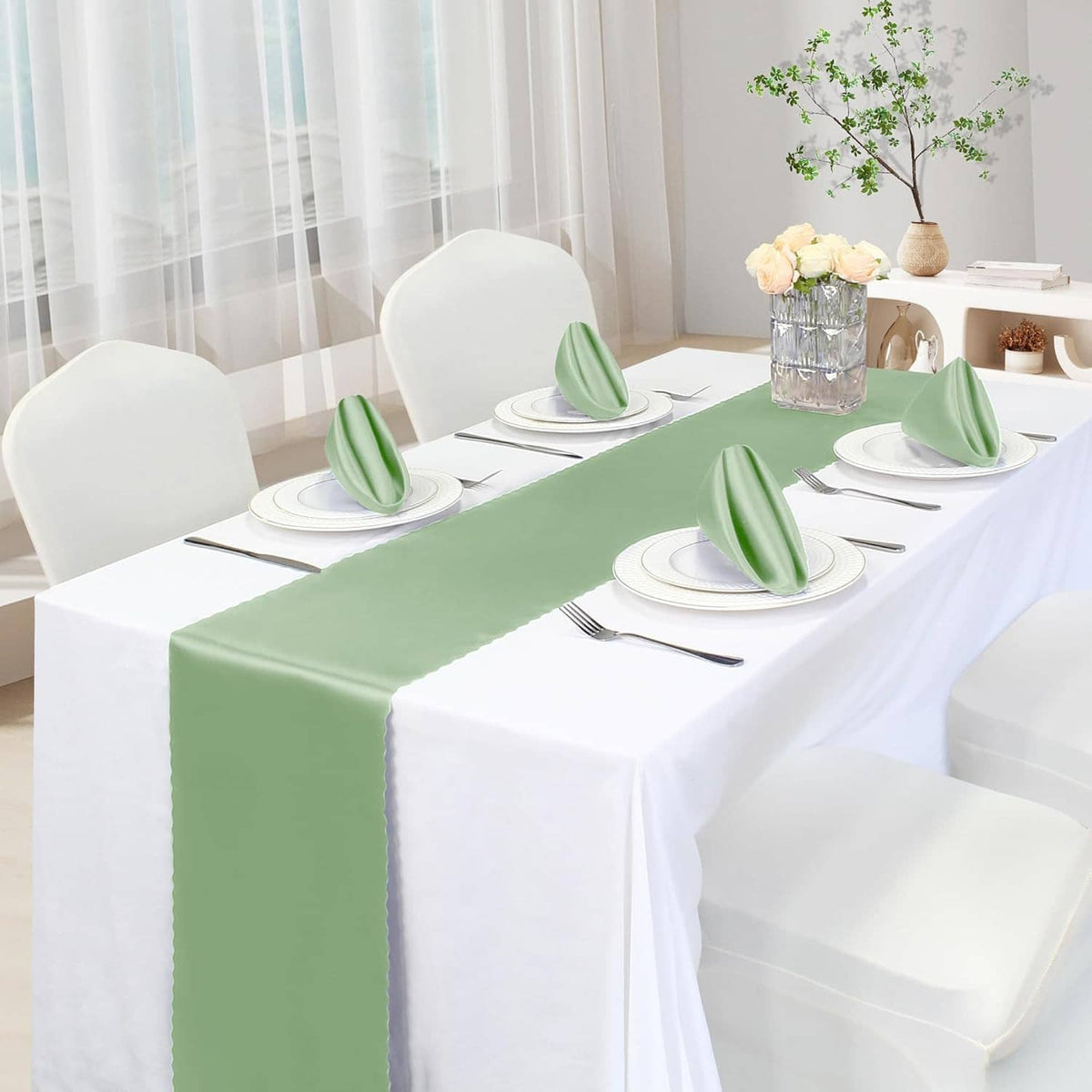 Sage green satin table runner with folded end drape on a dining table