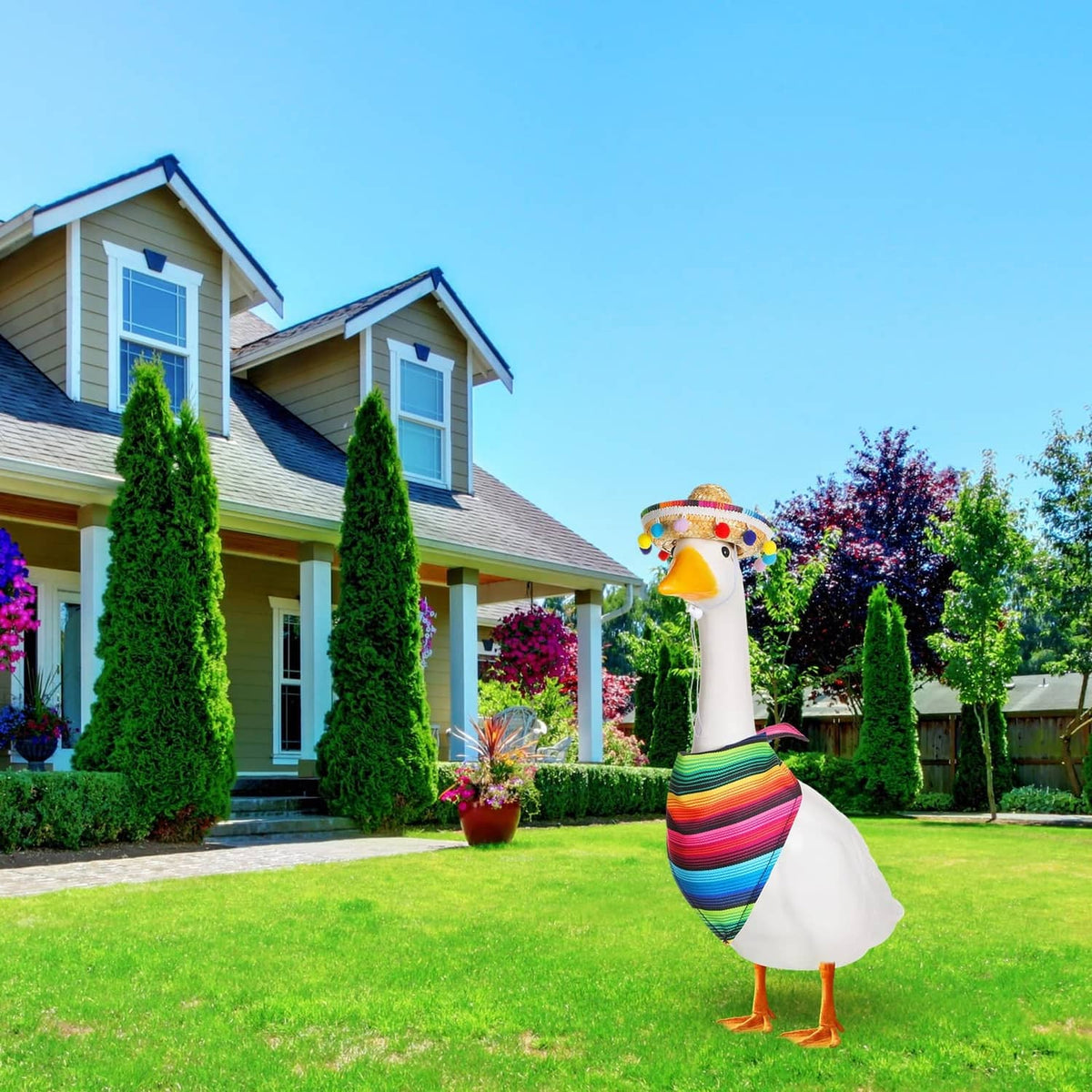 Multicolor porch goose wearing straw sombrero with pom-pom trim and rainbow striped wrap