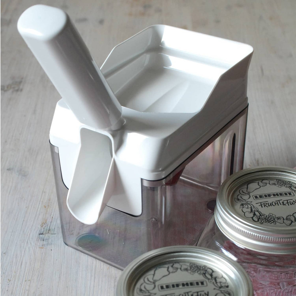 White Leifheit cherry stone remover with clear collection container on the base
