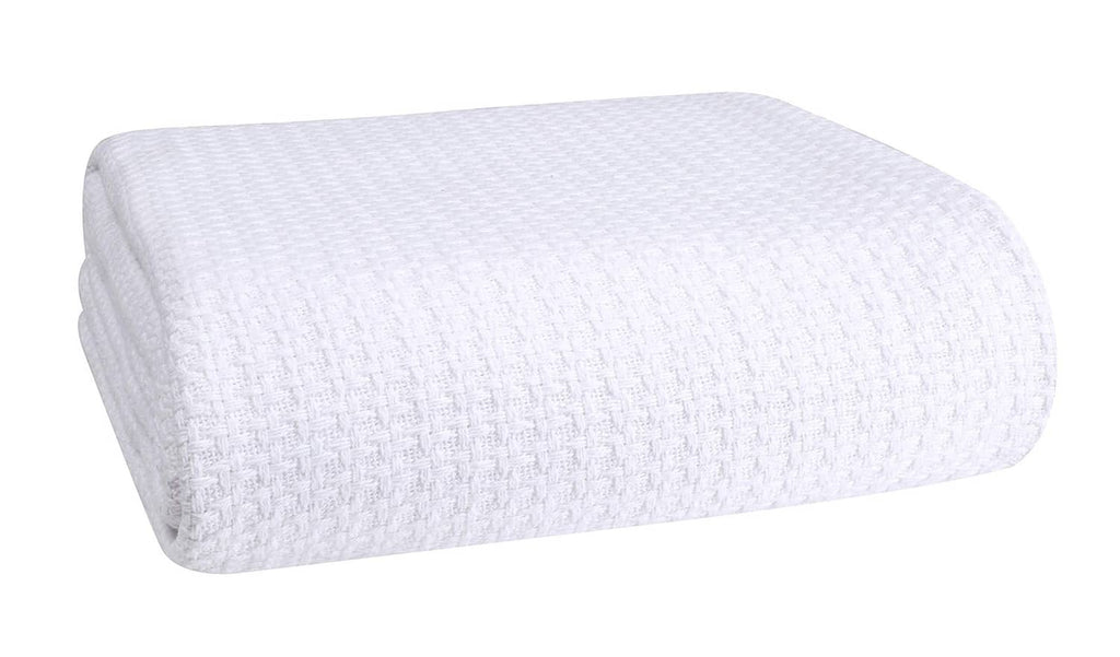 White cotton bed blanket, folded with waffle-texture weave.