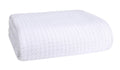White cotton bed blanket, folded with waffle-texture weave.