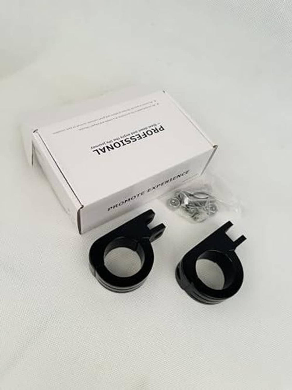 Black P-clamp foot peg mounts and silver hardware in retail packaging