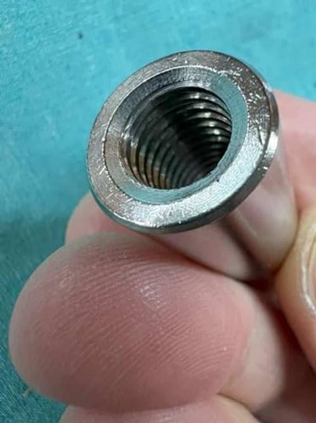 304 stainless steel M8 coupling nut close-up, internal screw threads visible