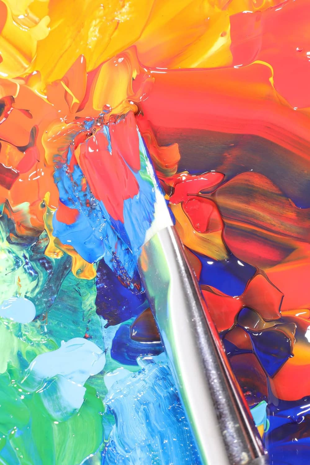 Close-up of acrylic paint with layered orange, red, and blue color swirls