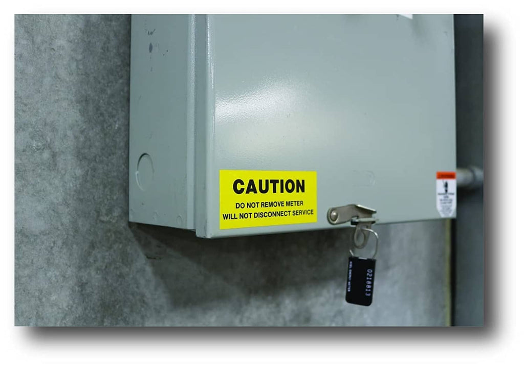 Small hanging label/tag near a CAUTION sticker on industrial equipment