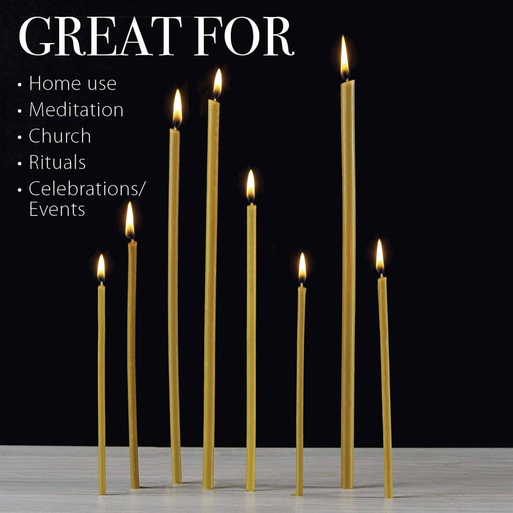 Set of tall beeswax taper candles standing upright with small flames on top.