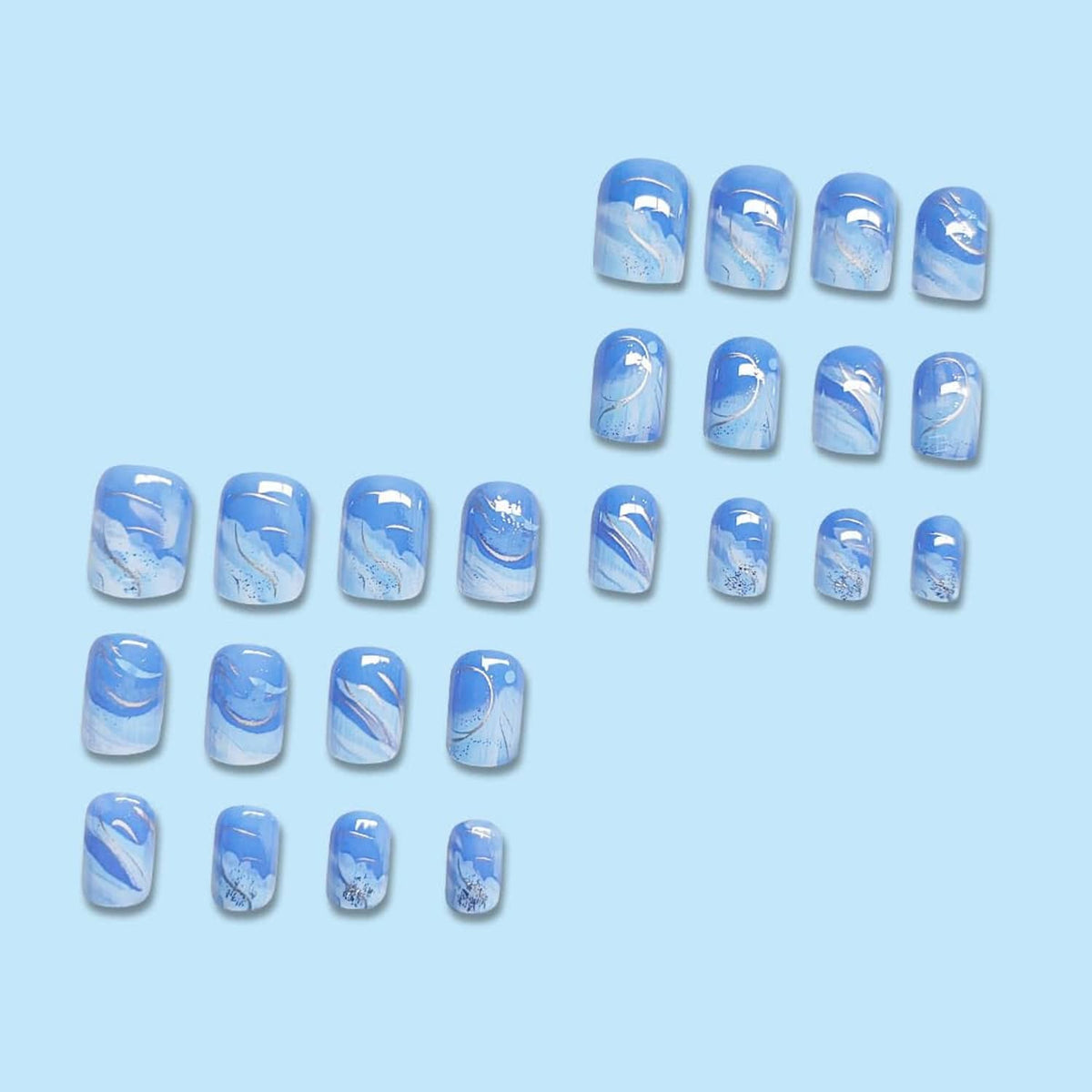 Assorted short square press-on nail tips in blue gradient with white and gold accents
