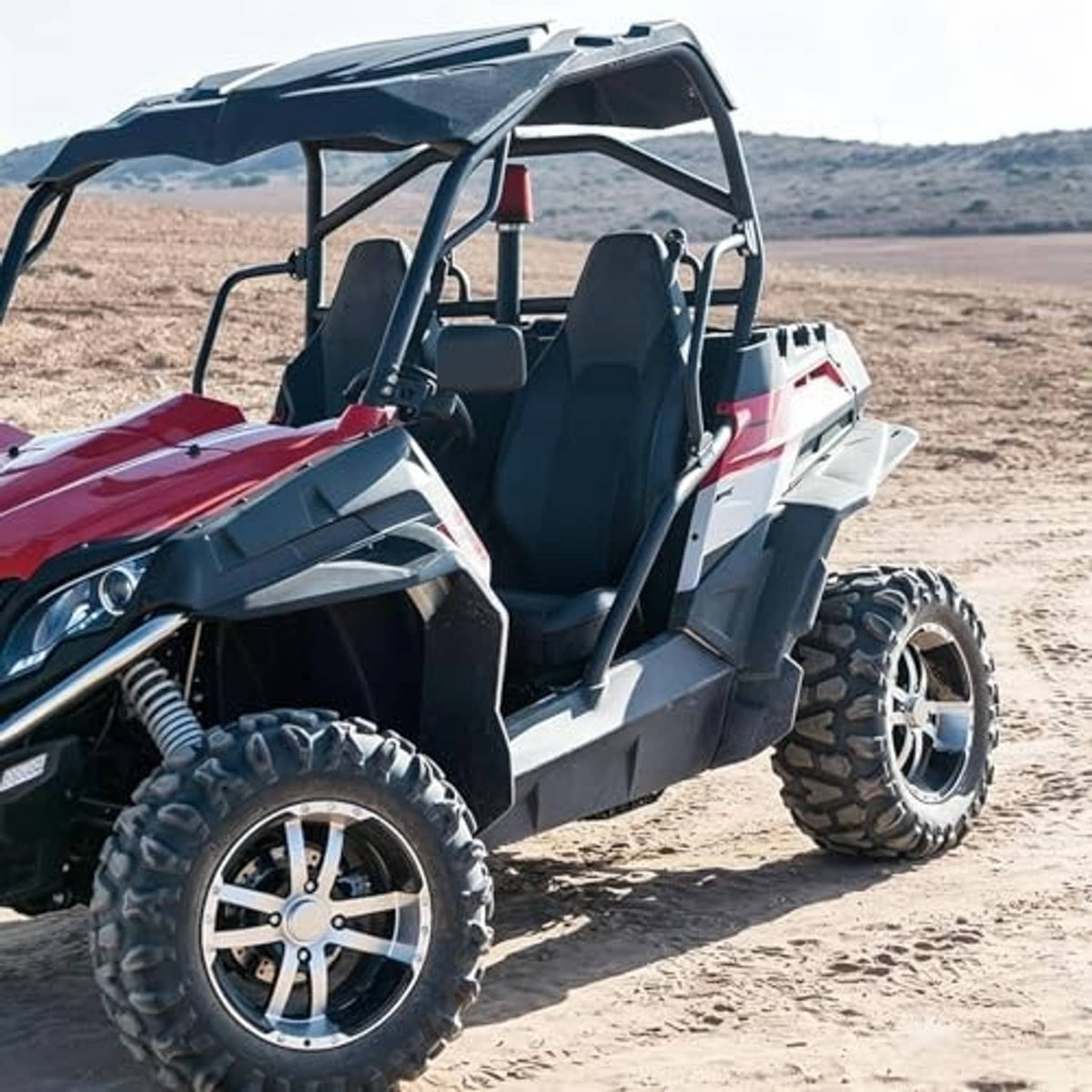 Off-road UTV with open cab, front wheels and headlights visible