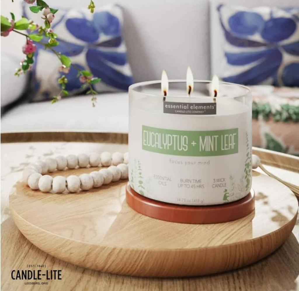 Eucalyptus mint leaf three-wick candle on round wooden tray with white jar