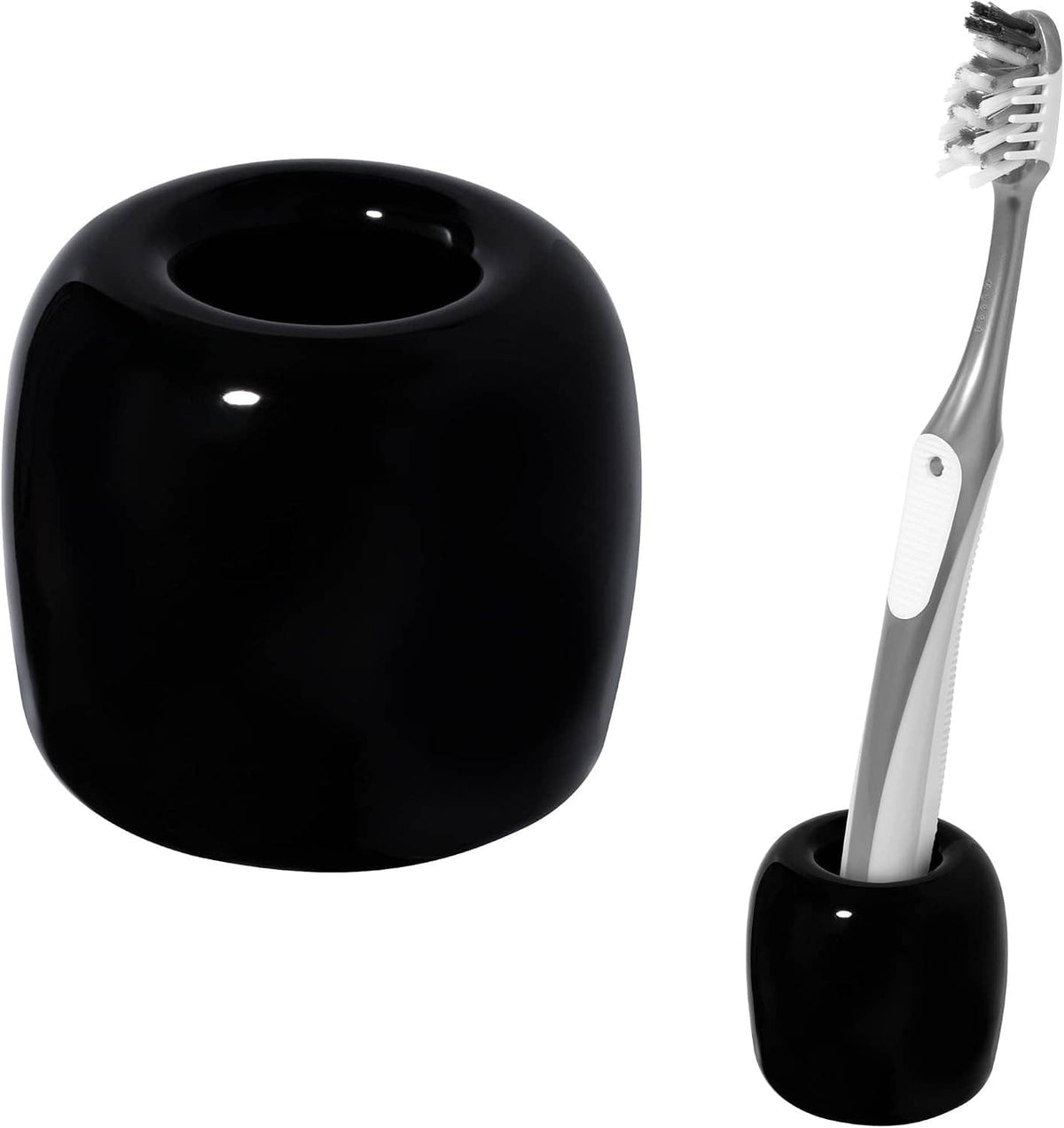 Black ceramic toothbrush holder with toothbrush standing in the round cup; smooth glossy finish.