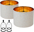 Set of two white linen drum lampshades with amber interior lining and harp top mounts
