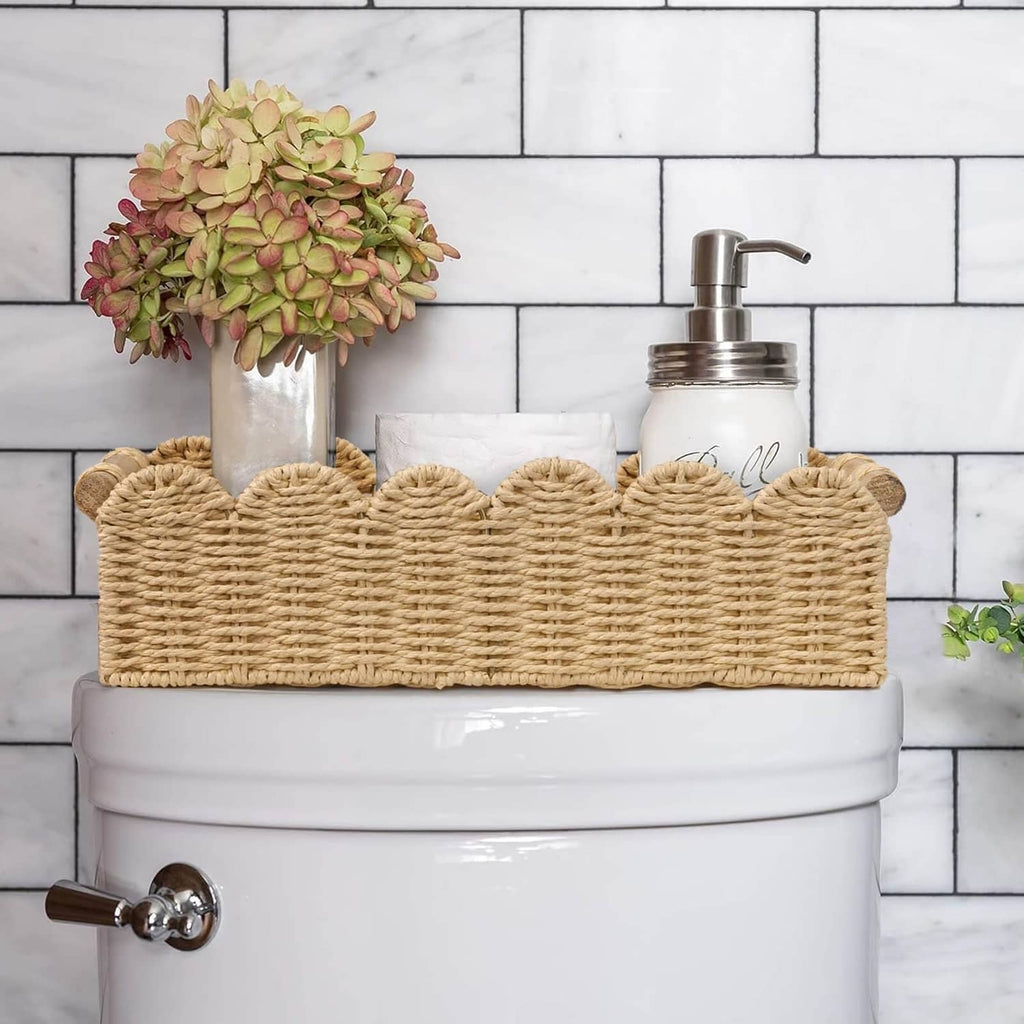 Beige scalloped woven toilet paper storage basket holding folded toilet tissue