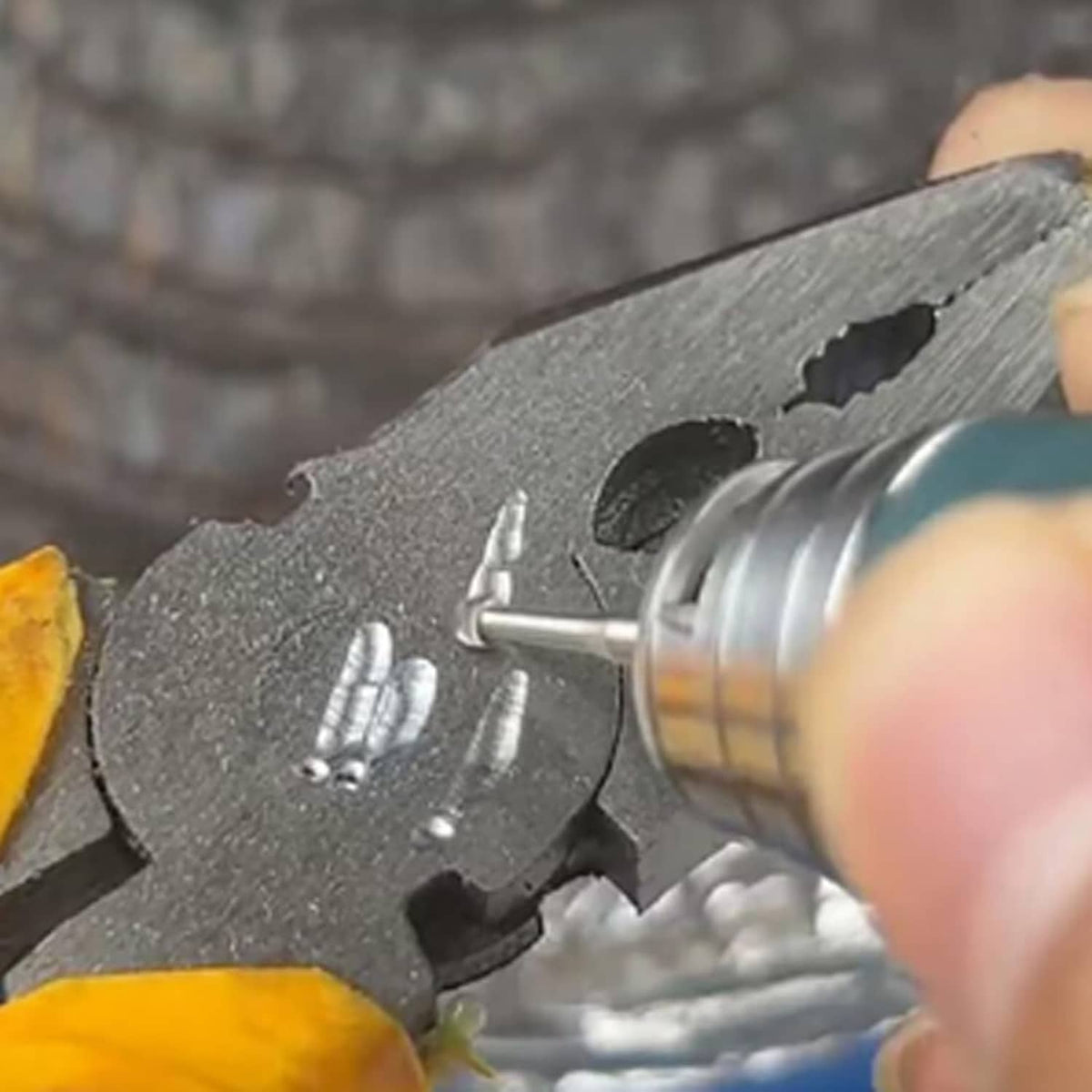Tungsten engraving bit carving into metal surface on a rotary tool
