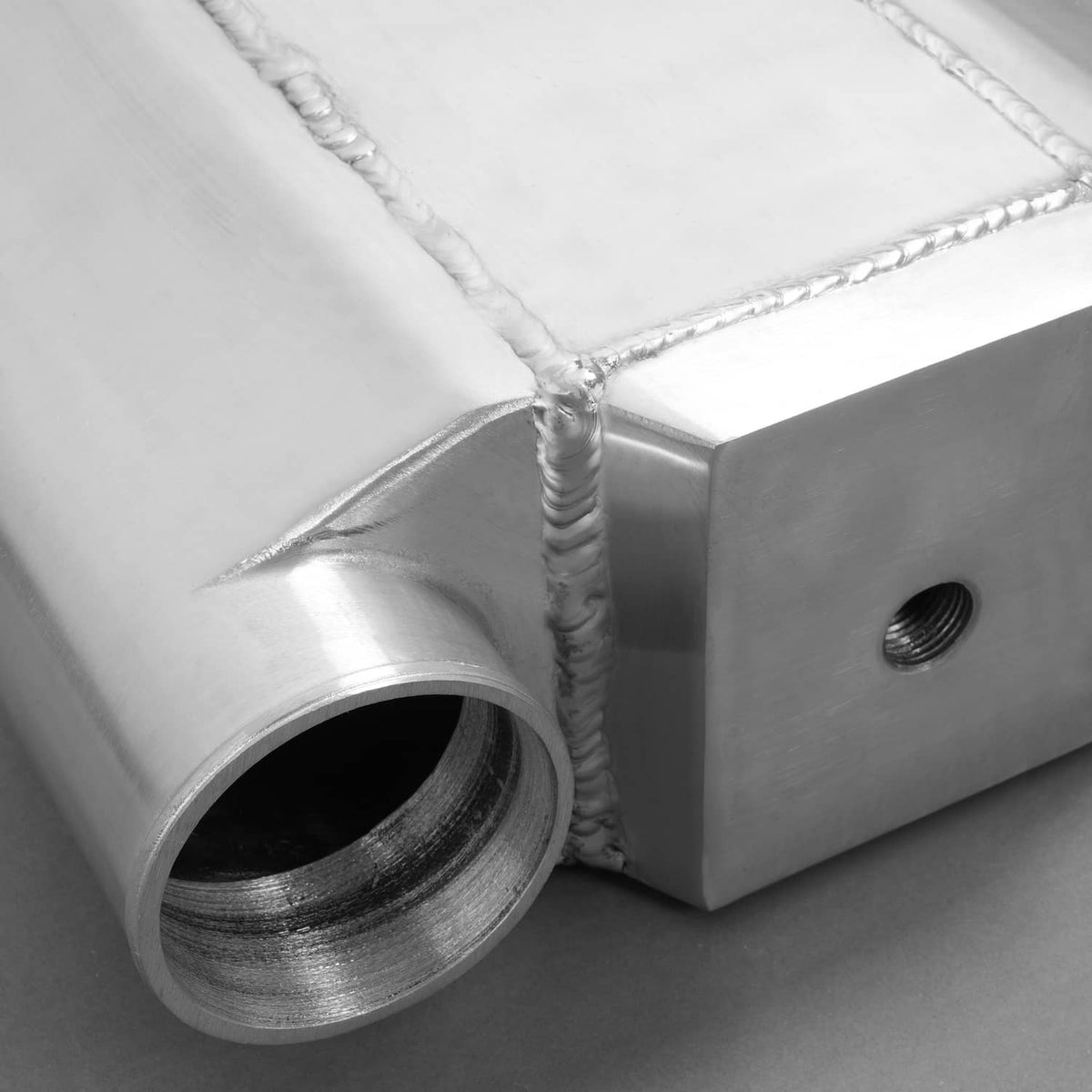 Universal air-to-water intercooler close-up of round port opening and threaded side boss