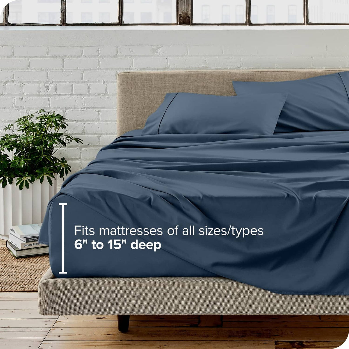 Blue twin bed sheet set with fitted sheet and two pillowcases on a cushioned frame
