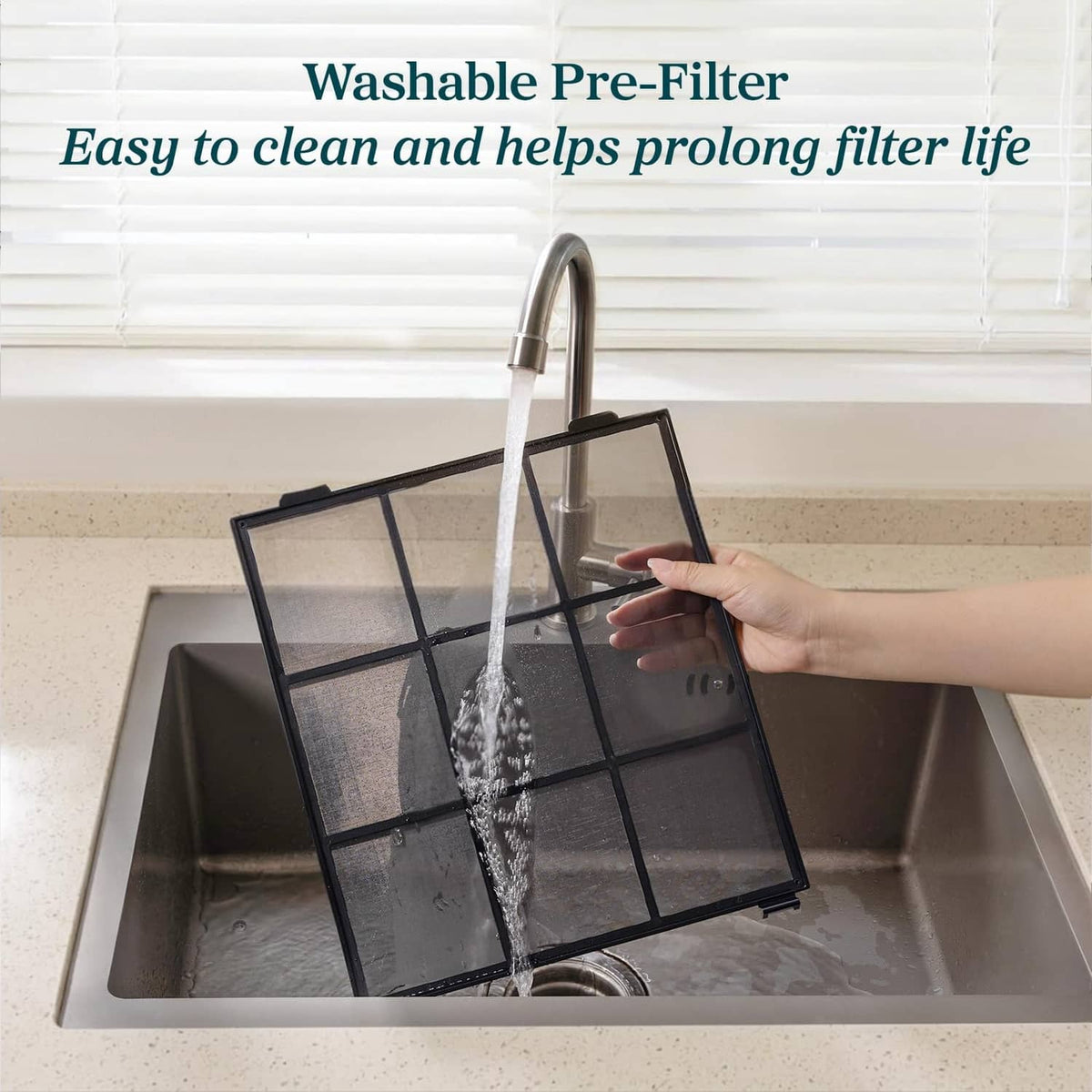 White LEVOIT air purifier washable pre-filter rinsed under running water.