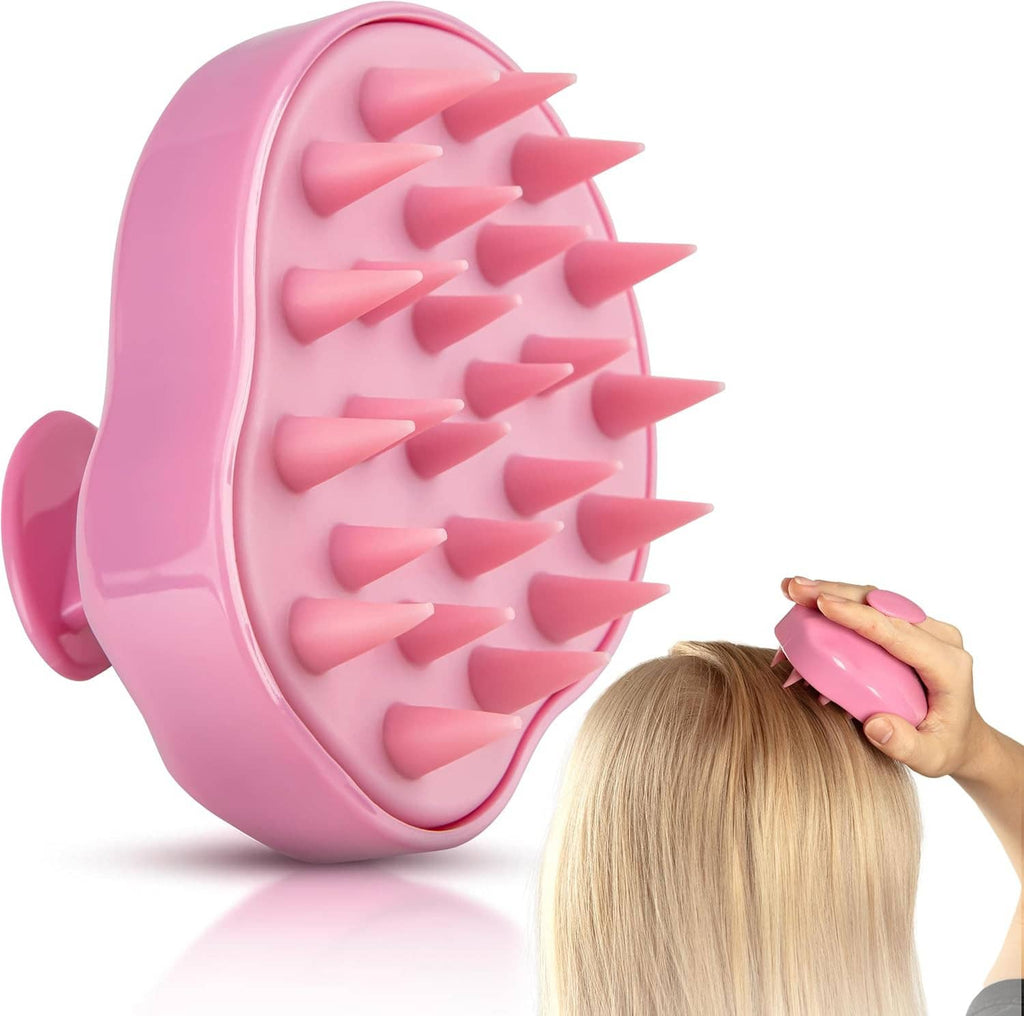 Pink scalp massager brush held near hair for scalp scrubbing