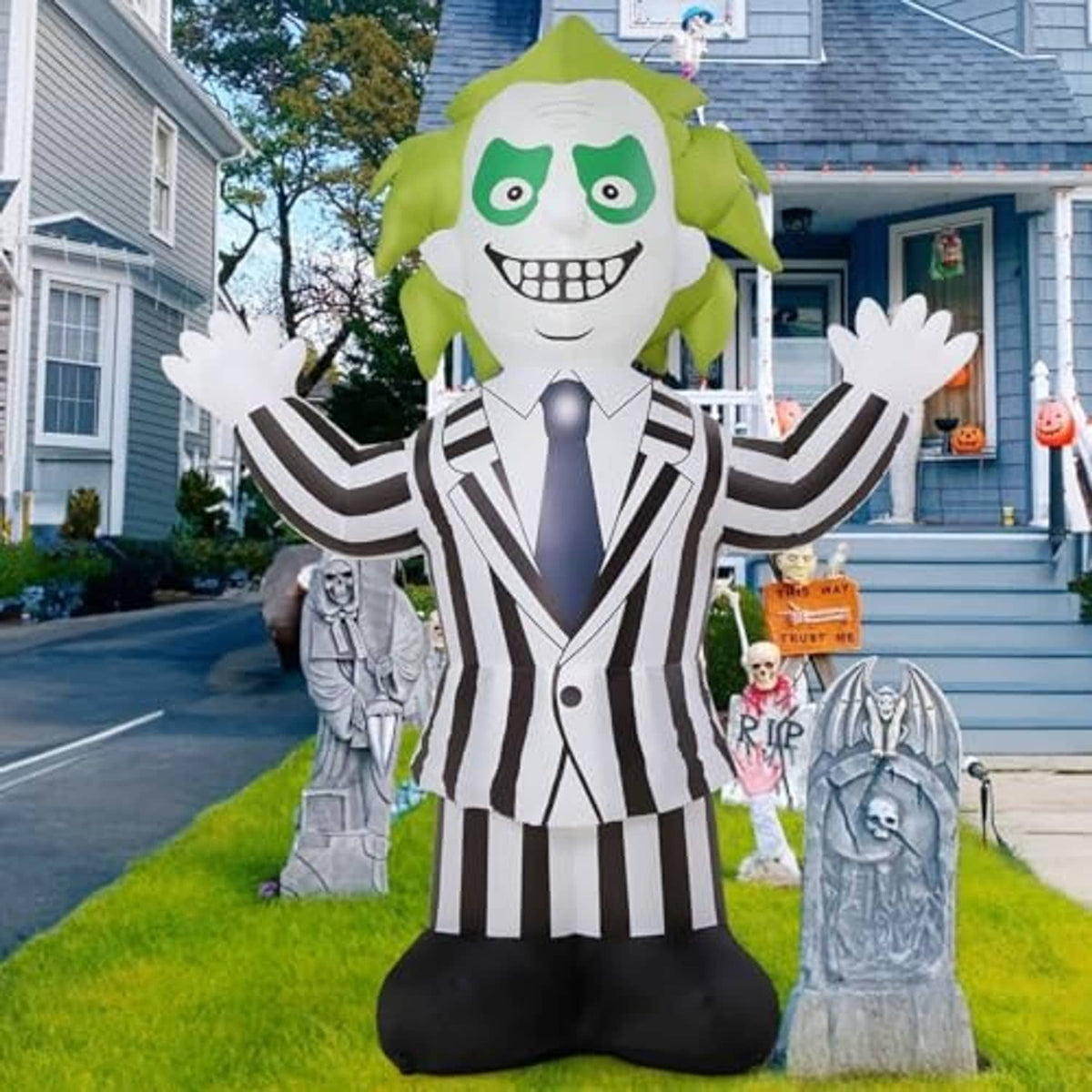 Inflatable Halloween weirdo yard decoration with green hair, grinning white face, striped outfit