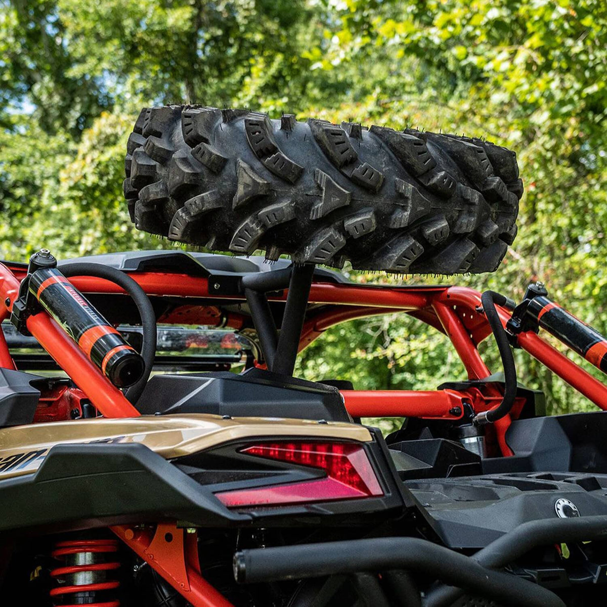 Spare tire carrier rack mounted on off-road ATV rear with spare wheel