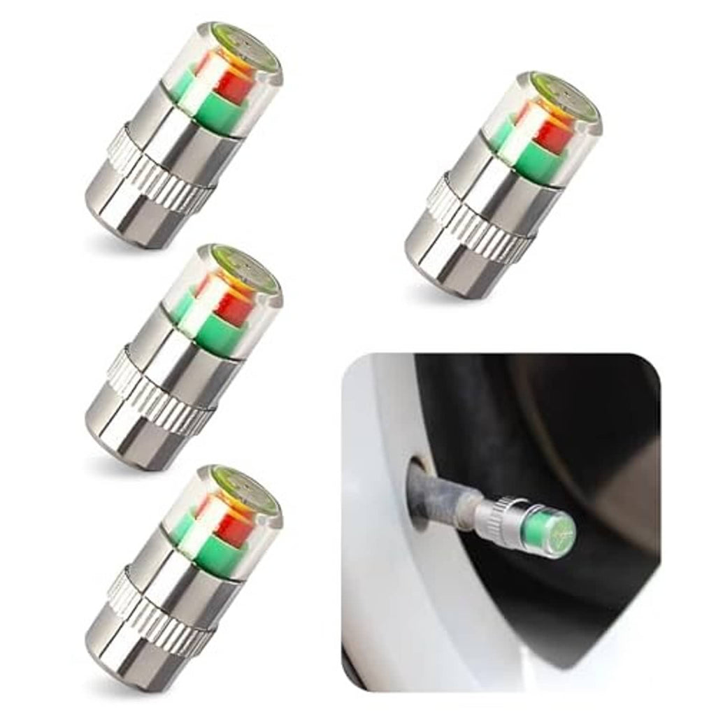 Four silver car tire valve stem caps with green red indicator rings, angled view