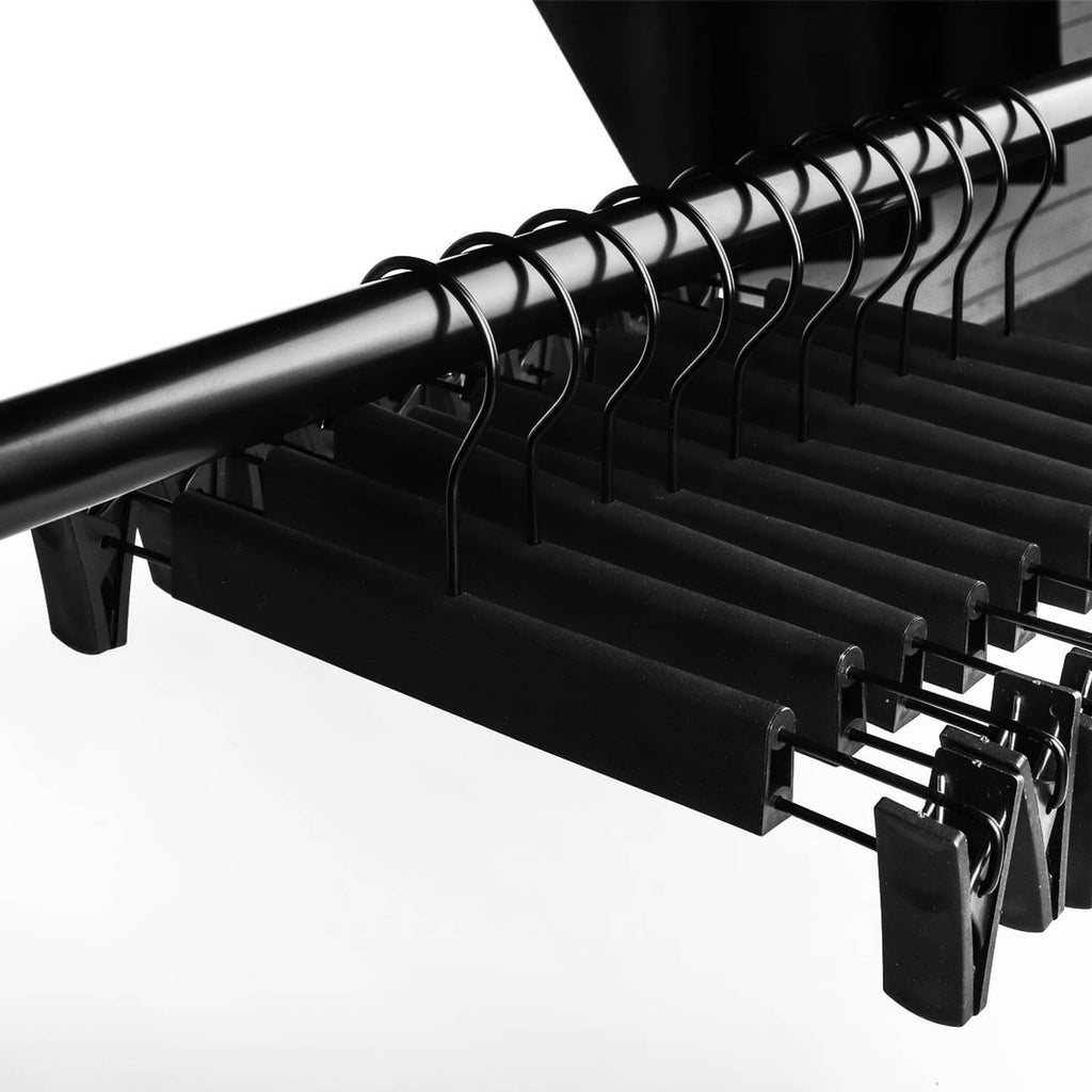 Black pants hanger close-up with evenly spaced adjustable clips and curved non-slip grips