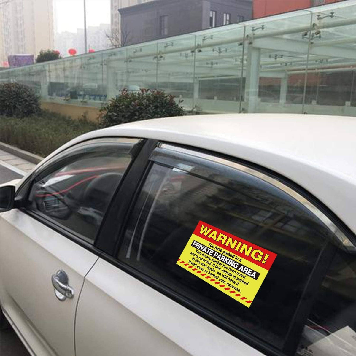 Private parking area warning sticker on car window glass, bold WARNING banner
