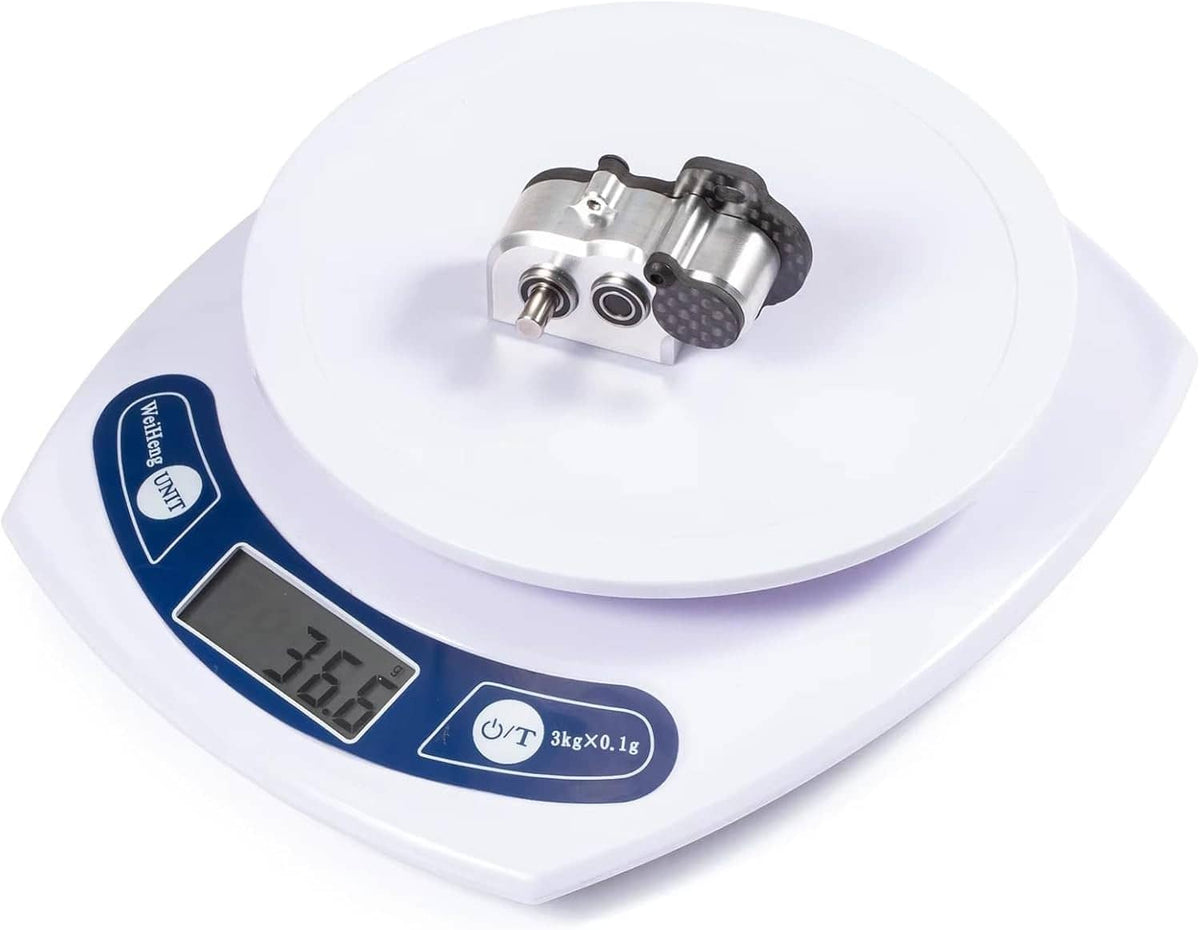 Ultralight tiny gearbox shown on digital scale, aluminum and carbon fiber