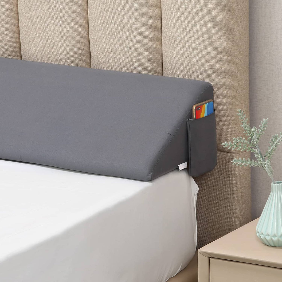 Gray bed wedge pillow with side storage pocket, angled for elevated head and support.