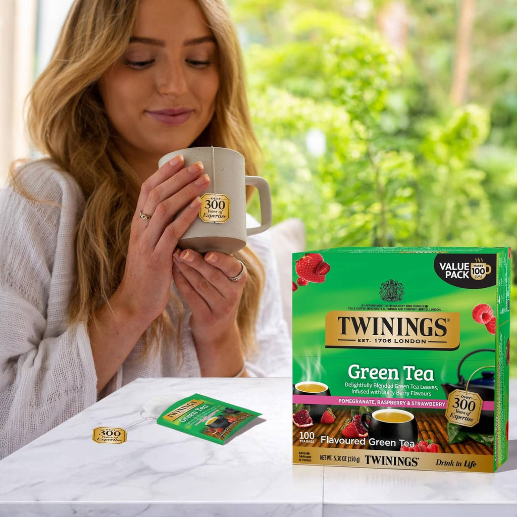 Green tea value pack beside tea mug held by woman