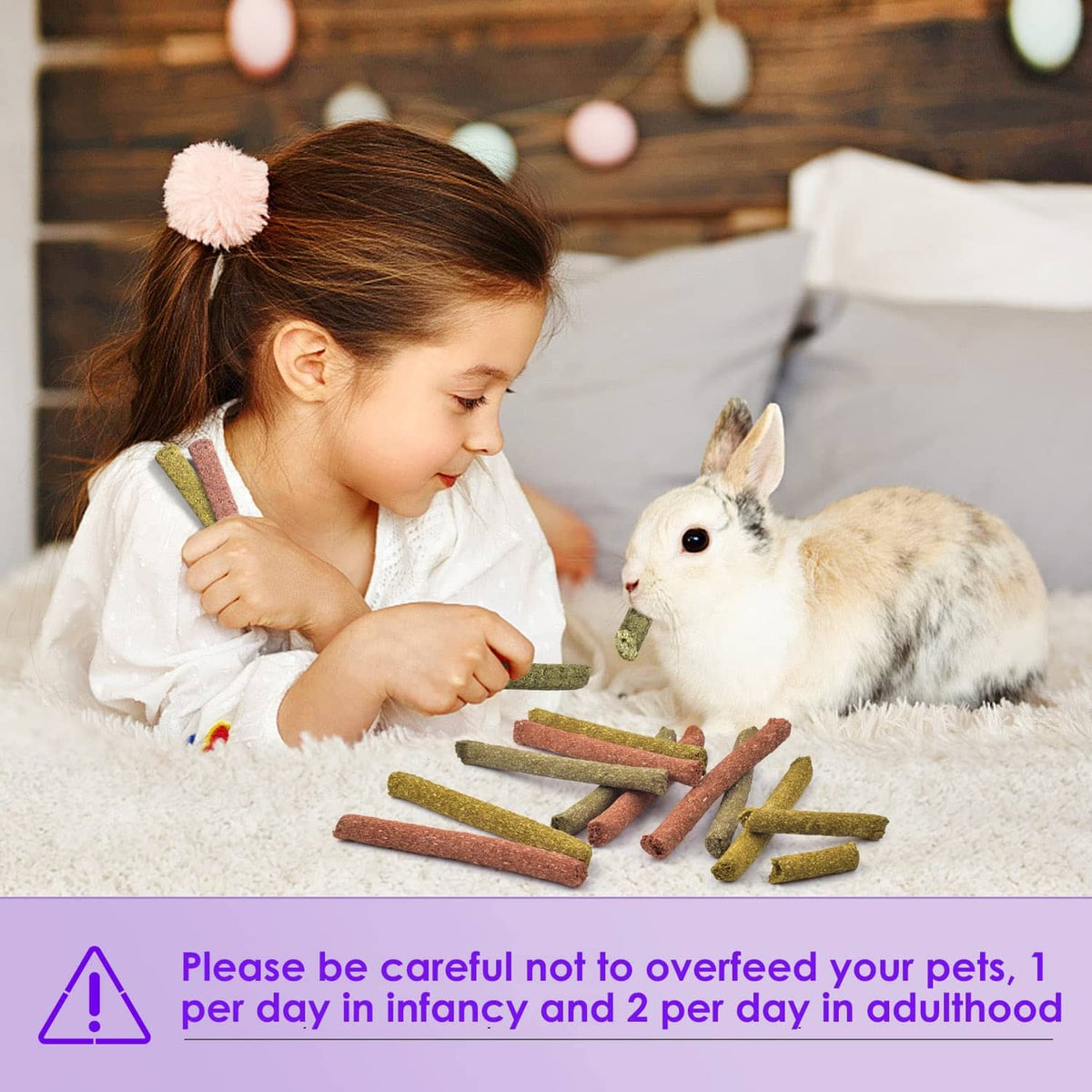 Child feeding a rabbit chew stick to a white rabbit with several sticks nearby