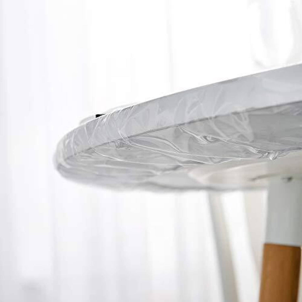 Transparent oval table cover tucked over tabletop edge for a snug fit
