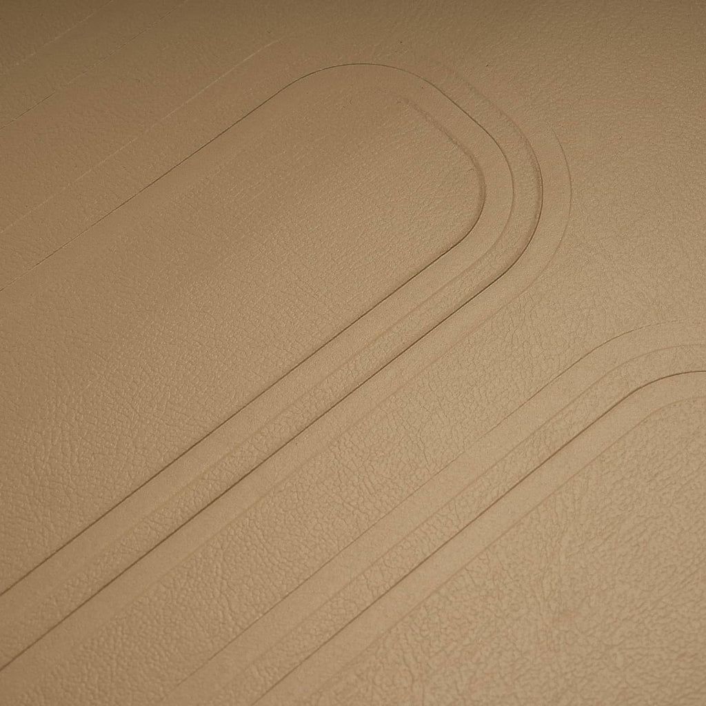 Close-up of tan faux leather upholstery with stitched seam lines
